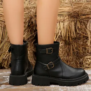 Detailed view of women's black platform ankle boots featuring side buckles and thick soles.