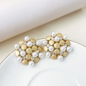 Detailed close-up of vintage sunflower stud earrings featuring white pearls and shimmering rhinestones