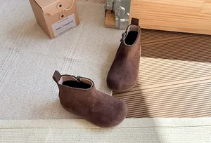 Vintage bruine suède enkellaarsjes voor kinderen met zijrits in een warme lifestyle setting