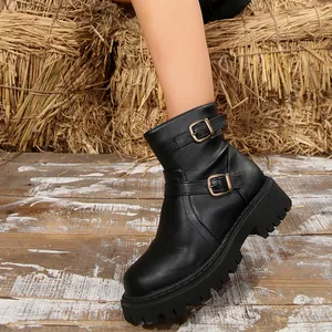 Detail view of black chunky platform ankle boots with double buckles and lug sole.