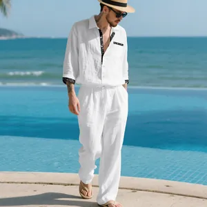 Elegant man wearing a white long-sleeve linen shirt and matching pants set by the sea