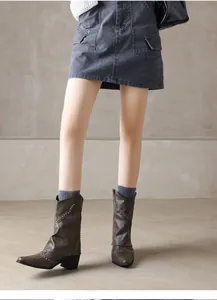 Detail view of vintage brown Western ankle boots with rivet studs and pointed toe