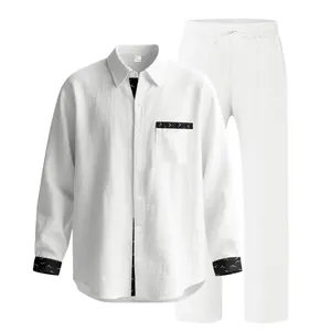 Detailed view of white linen two-piece set with black patterned cuffs and pocket trim.
