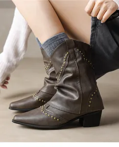 Detailed macro shot of vintage brown western ankle boots featuring elegant golden stud accents