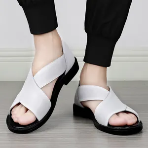 Gros plan de sandales en cuir blanc pour hommes avec brides croisées et semelles noires