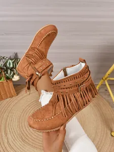 Detailweergave van bruine suède franjelaarzen in western cowboy-stijl met studs