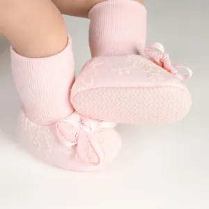 Detailed macro view showing the anti-slip bottom dots and lace bow on pink baby socks