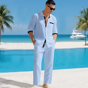 Caucasian male model wearing light blue linen shirt and trousers set by tropical beach