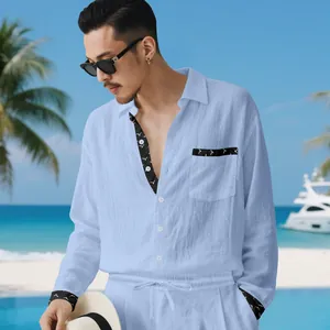 Mens light blue linen shirt and trousers set with patterned trim on a beach background