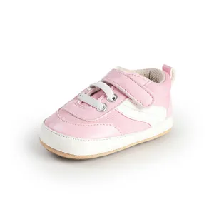 Close-up of a pink canvas baby pre-walker shoe with velcro strap and white laces