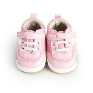 Top view of pink baby walking shoes with white velcro straps and decorative laces