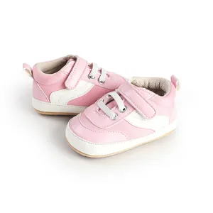 Detailed macro view of pink and white infant canvas sneakers with soft soles and straps