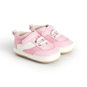 Close-up view of pink baby canvas walking shoes with velcro strap and white laces
