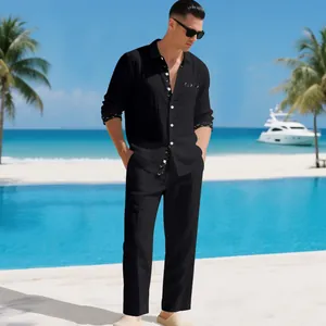 Men's black linen suit set styled at a tropical beach with a pool and palm trees