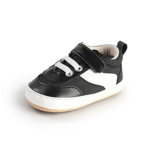 Detail of black and white baby walking shoes with soft soles and velcro strap