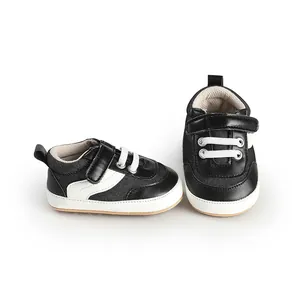 Pair of black and white canvas baby walking shoes with velcro strap for infants