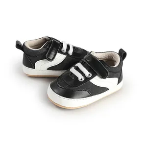 Close-up of black and white infant canvas walking shoes with convenient hook-and-loop strap