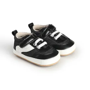 Detailed macro view of black and white infant canvas sneakers with easy velcro straps.