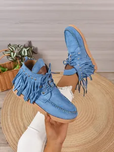 Blauwe suède western franjelaarzen met studs en veters in een lifestyle setting