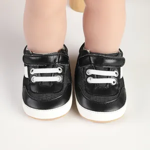 Macro view of black baby canvas pre-walker shoes with white laces and Velcro.