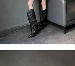 Detailed view of stylish black slouchy high-top boots with a sleek pointed toe design