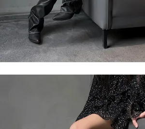 Close-up detail of black slouched high-heeled long boots with pointed toe