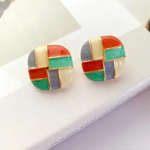 Close-up of vintage colorful patchwork enamel stud earrings with elegant gold-toned trim