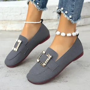 Detailansicht grauer flacher Slipper mit eckiger Zehenpartie und Strass-Schnalle