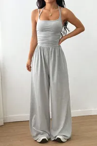 Detailansicht der gerafften Taille und des weiten Beindesigns eines grauen Jumpsuits.