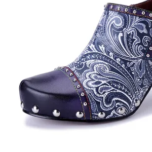 Close-up of printed leather high heel with intricate floral patterns and silver studs