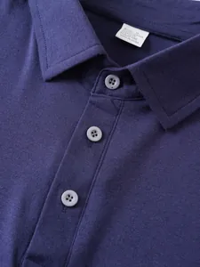 Vista dettagliata del colletto e dei bottoni di una polo da uomo blu navy e della trama