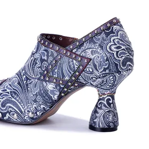 Close-up detail of vintage blue paisley printed leather high heels with silver studs