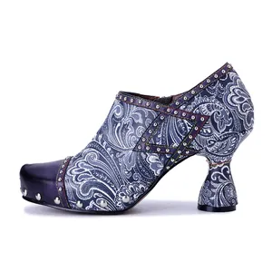 Side view of a vintage bohemian floral print leather high heel shoe with metallic rivet details