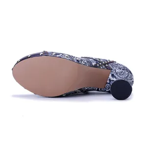 Detailed view of women's leather pump with paisley print, silver rivets and round heel