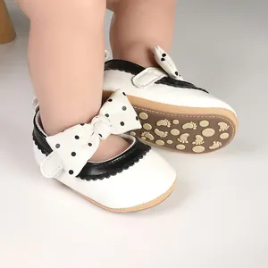 Detailed view of soft-soled white baby girl walker shoes with black polka dot bow