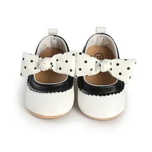 Close-up of white baby girl princess walker shoes featuring black polka dot bows detail