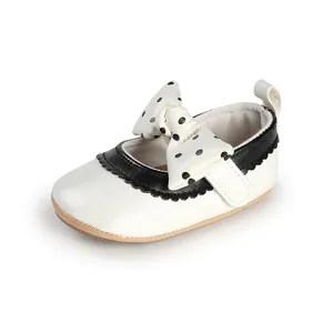 Detailed view of baby girl white Mary Jane shoes with black polka dot bow