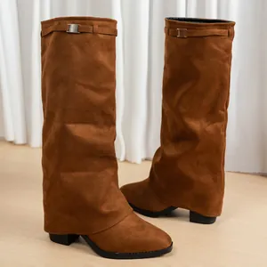 Détail de bottes montantes en daim marron avec un design élégant de jambe de pantalon