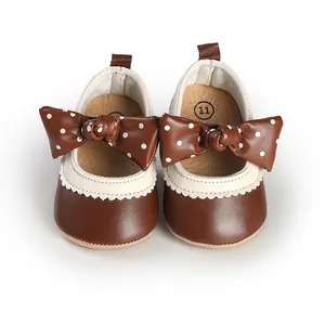 Detail view of brown infant princess walker shoes with polka dot bow decoration
