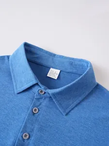 Dettaglio del colletto di una polo blu da uomo con etichetta materiale e trama tessuto