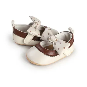 Detail view of cream and brown baby princess shoes with polka-dot bow decoration