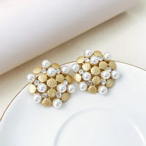 Detail of gold sunflower earrings with faux pearls and sparkling rhinestones