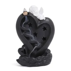 Black heart-shaped backflow incense burner with white cupid angel figurine on top