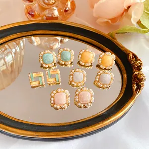 Detail shot of vintage French enamel pearl stud earrings in various pastel colors