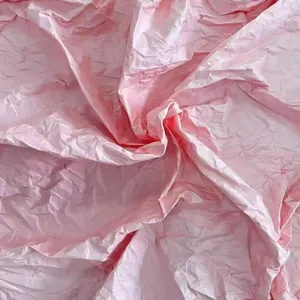 Macro texture detail of light pink crumpled hand-rubbed paper for DIY flower crafts