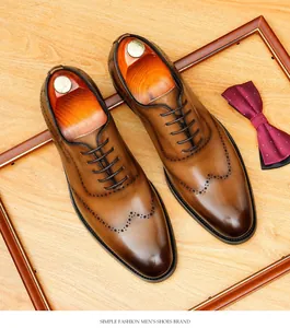 Détail de la patine faite main et des motifs brogue sur des chaussures richelieu en cuir brun.