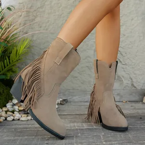 Detalle de botines estilo cowboy de ante beige con flecos laterales y tacón cuadrado