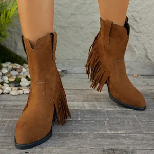 Primer plano de botas vaqueras de ante marrón con flecos y diseño de puntera afilada