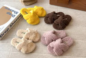 Varietà di accoglienti pantofole colorate in ecopelliccia incrociata per bambini su tappeto