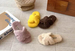 Dettaglio di ciabatte pelose colorate con cinturini incrociati per bambini in pile